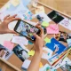 Seseorang menggunakan smartphone untuk mendokumentasikan moodboard kreatif, langkah awal penting dalam merancang identitas visual yang konsisten untuk Brand Awareness Strategy.